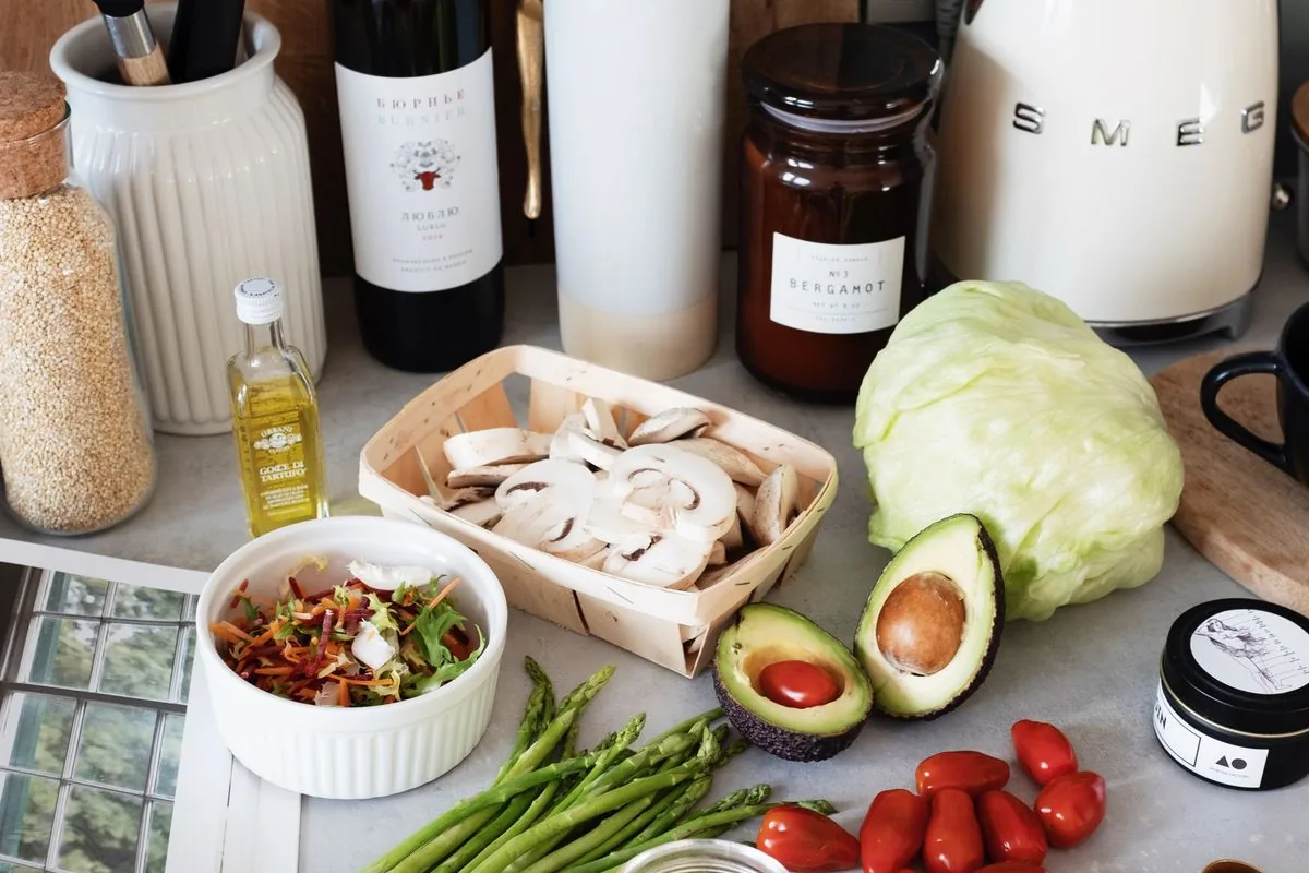 Fresh vegetables and pantry ingredients on a kitchen counter before cooking.